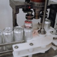 cans being sealed in factory - DemandCaster