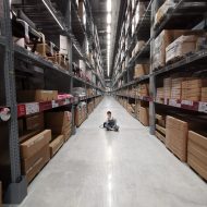 person sitting on shop floor in aisle in warehouse | inventory optimization | DemandCaster