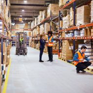 workers in warehouse full of boxes | DemandCaster