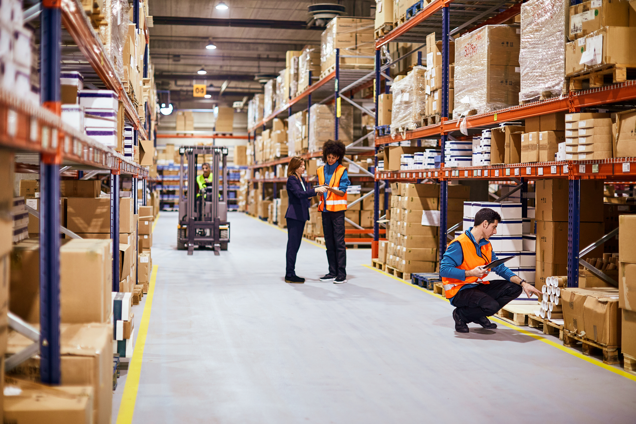 workers in warehouse full of boxes | DemandCaster