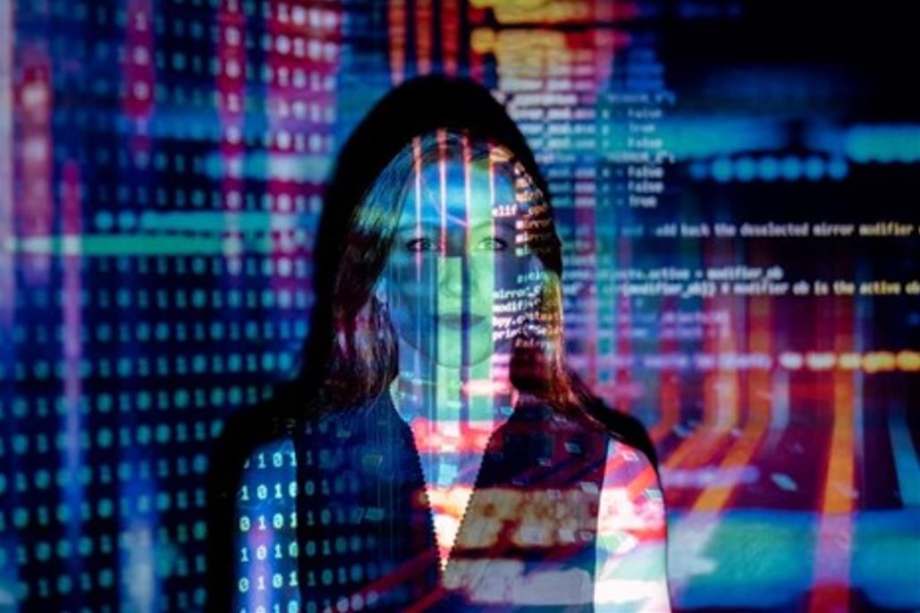 woman standing in front of data screen projection
