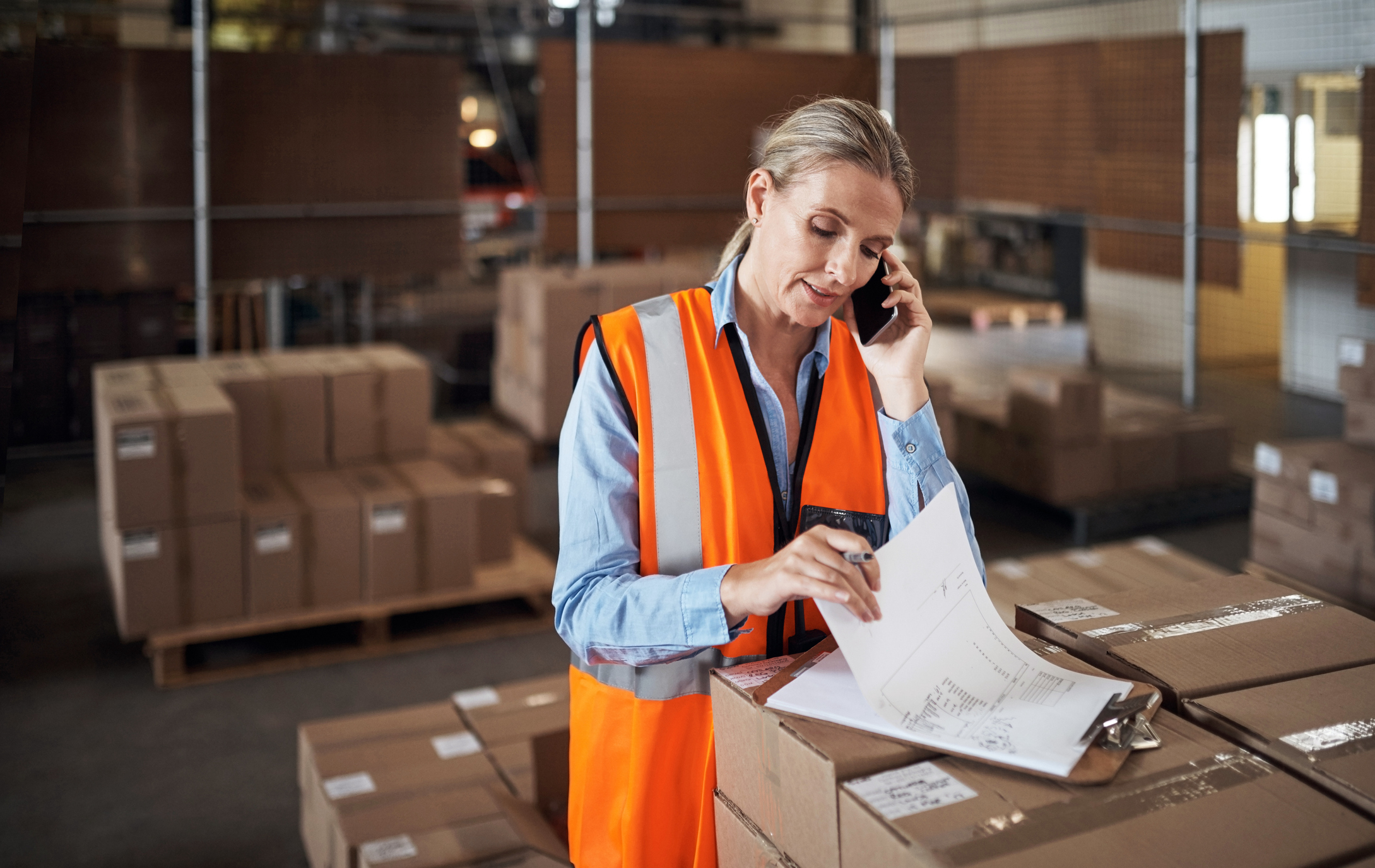 woman looking at paperwork in warehouse