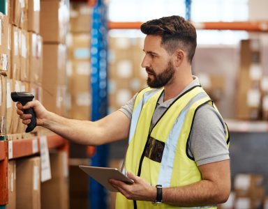 Man scanning boxes in warehouse