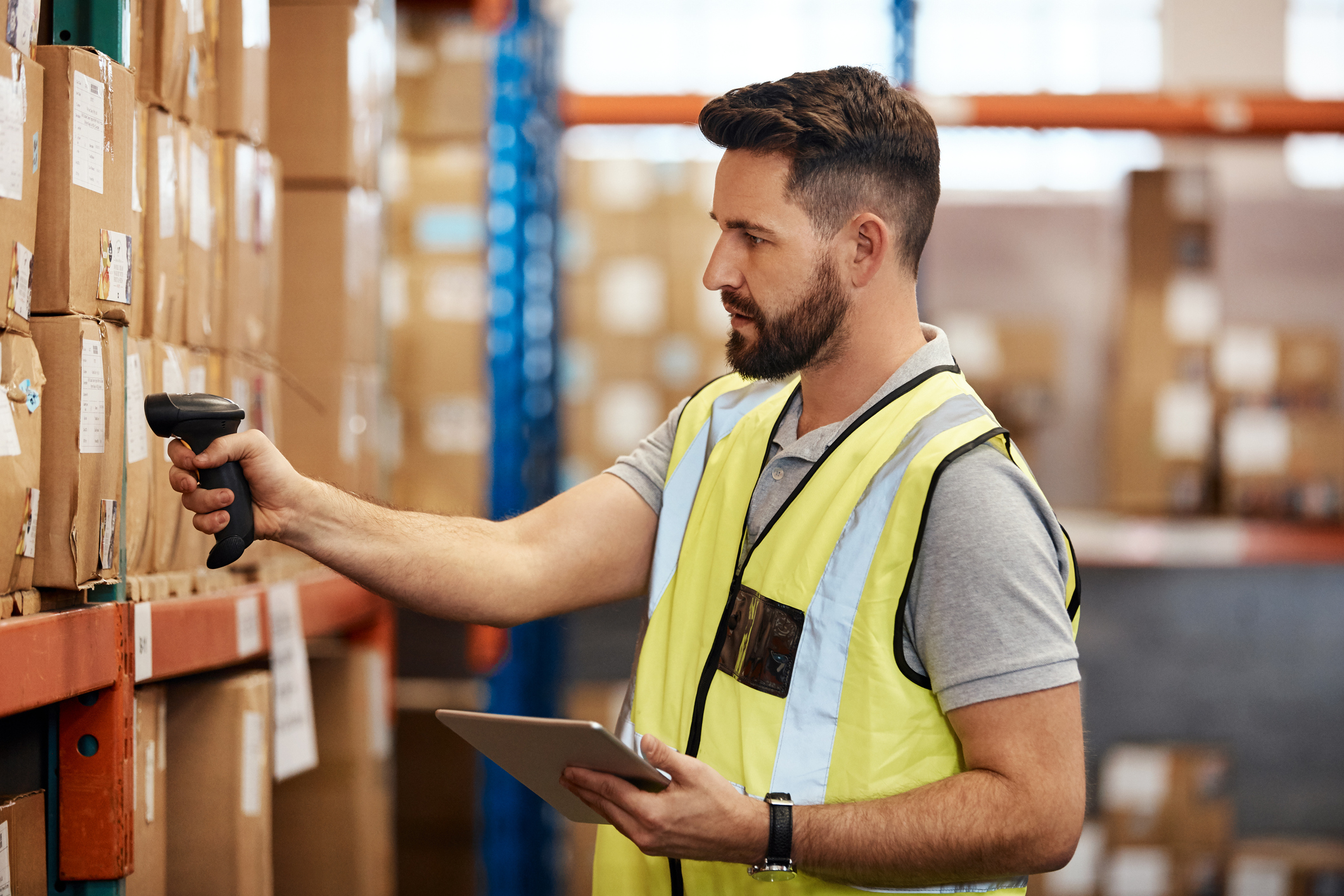 Man scanning boxes in warehouse